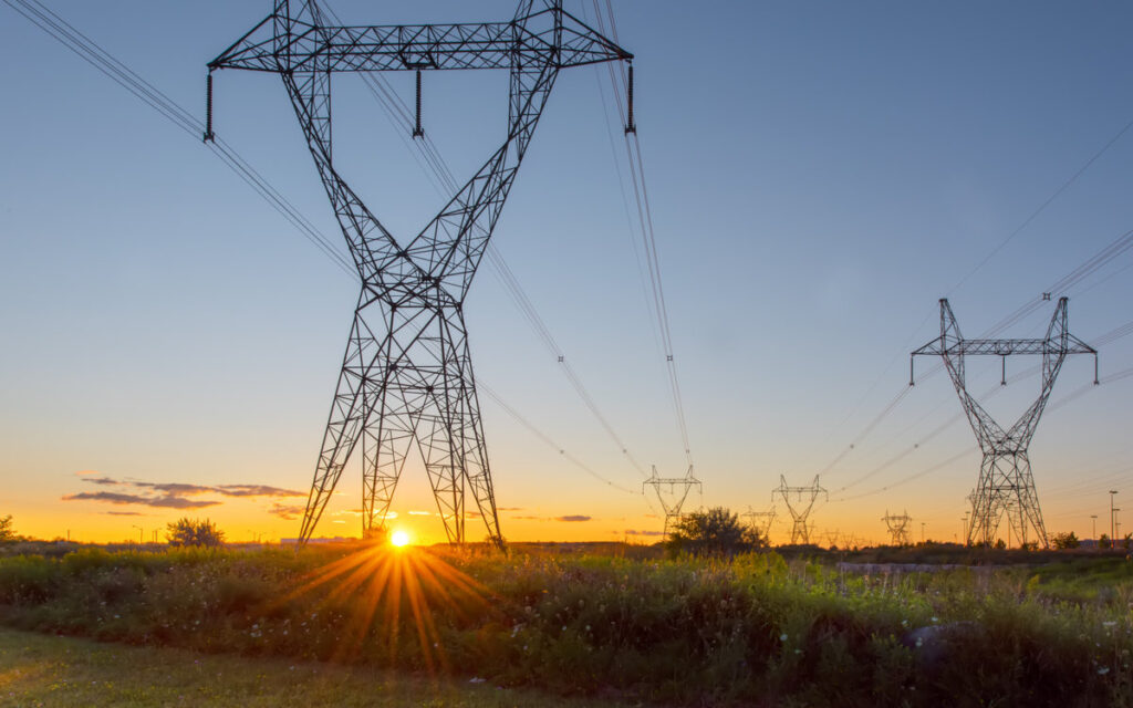 Two sets of powerlines run parallel through open Ontario field